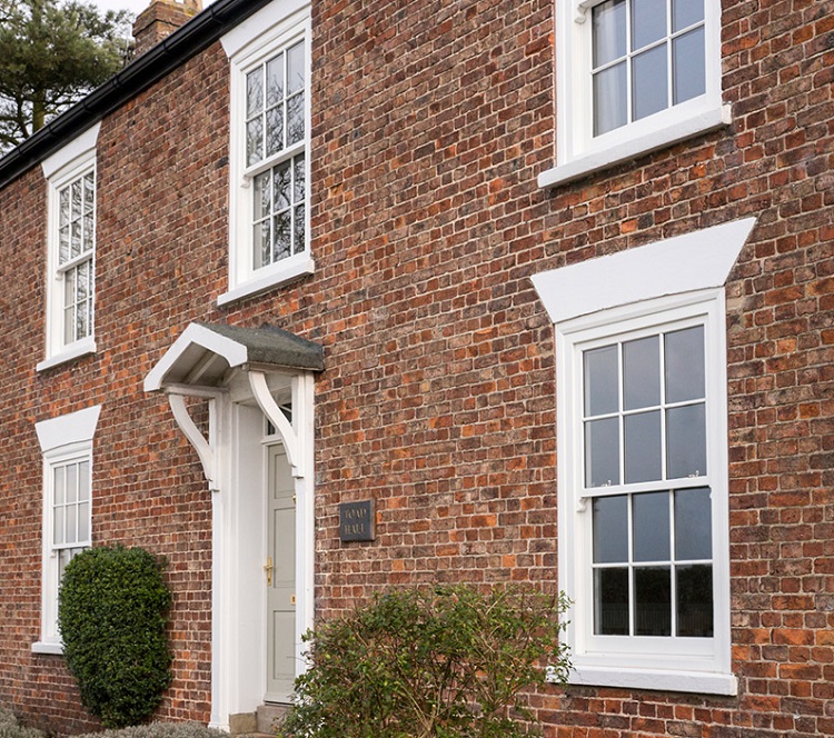 Exterior of a brick house with white framed windows